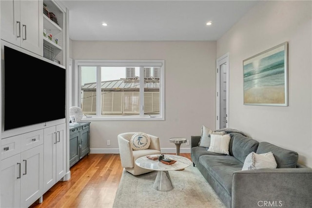 living area with recessed lighting, baseboards, and light wood-style flooring