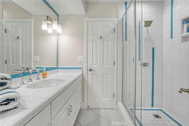 full bath with vanity, a shower stall, and tile patterned flooring