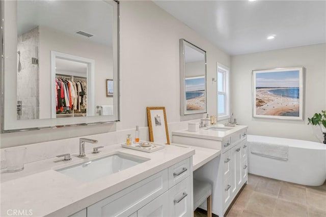 bathroom with vanity, a tub to relax in, and tile patterned floors