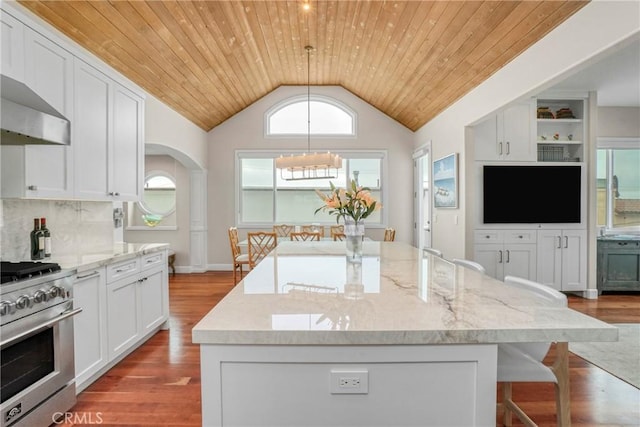 kitchen featuring lofted ceiling, high end range, a center island, light stone countertops, and wooden ceiling