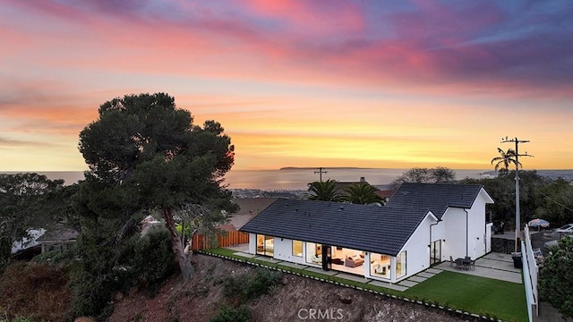 exterior space featuring a yard, a patio area, and a water view