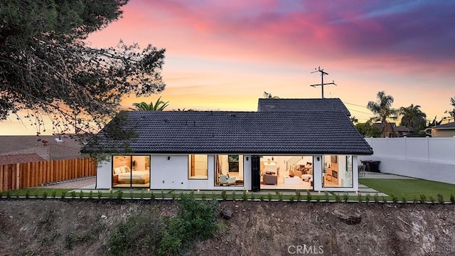 back house at dusk with a patio