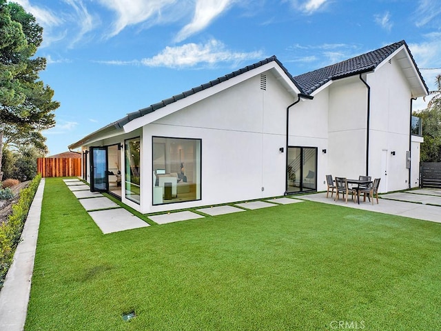 rear view of house with a patio area and a lawn