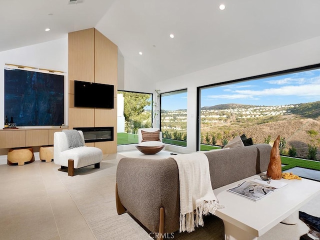 living room with a large fireplace and high vaulted ceiling