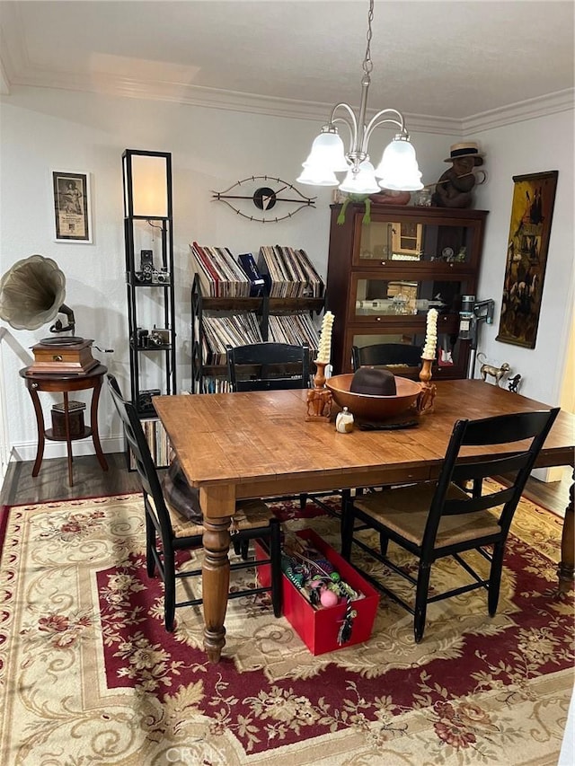 dining room featuring ornamental molding, hardwood / wood-style flooring, and a chandelier