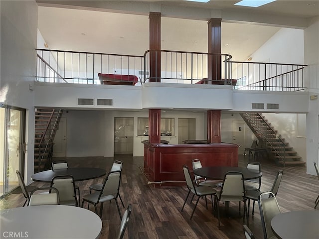 dining room with dark hardwood / wood-style flooring and a towering ceiling