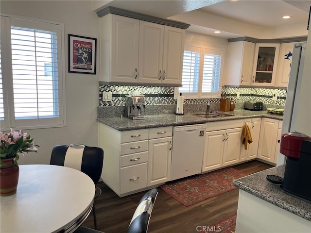 kitchen featuring white dishwasher, white cabinets, backsplash, sink, and dark hardwood / wood-style floors