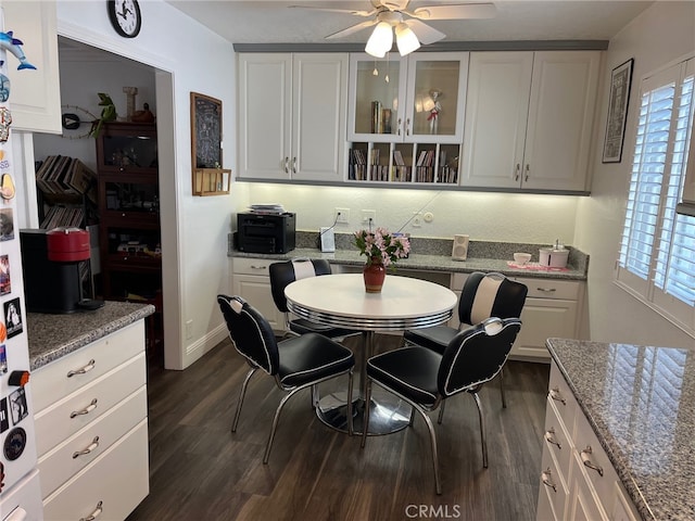 kitchen featuring ceiling fan, dark wood-type flooring, white cabinetry, and light stone countertops