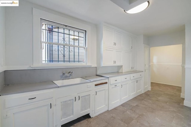 kitchen featuring sink and white cabinets