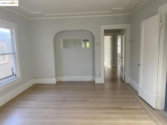 spare room with light hardwood / wood-style flooring, ornamental molding, and plenty of natural light