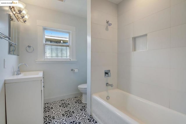 full bathroom featuring tiled shower / bath combo, vanity, tile patterned floors, and toilet