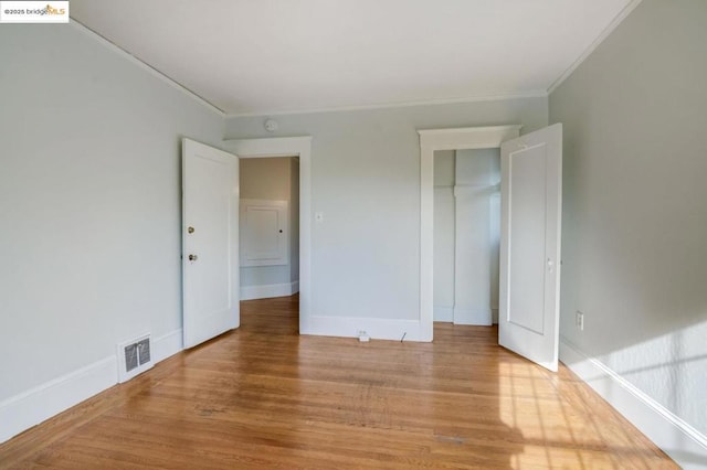 unfurnished bedroom featuring ornamental molding and light hardwood / wood-style flooring