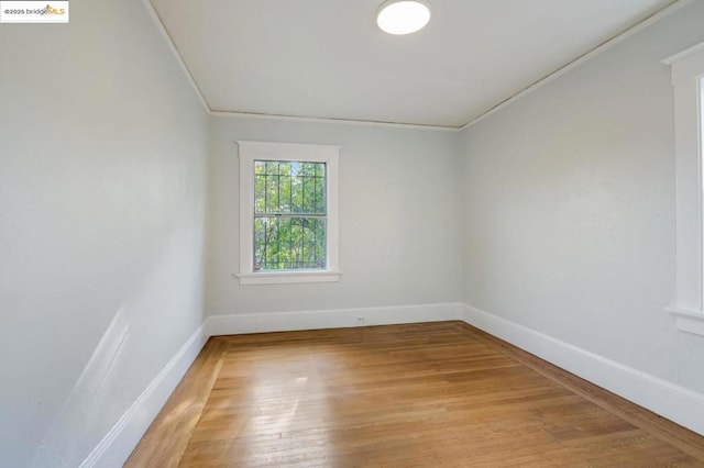 unfurnished room featuring ornamental molding and light hardwood / wood-style flooring