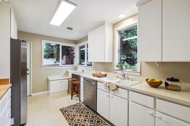 kitchen with sink, stainless steel appliances, and white cabinets