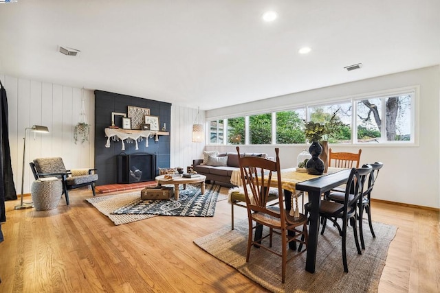 dining room with a fireplace and light hardwood / wood-style floors