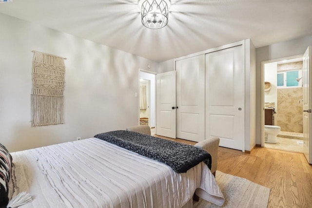 bedroom featuring ensuite bath, a closet, and light wood-type flooring