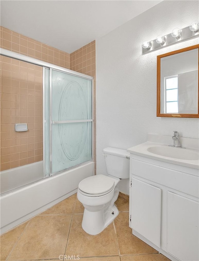 full bathroom featuring tile patterned flooring, vanity, combined bath / shower with glass door, and toilet