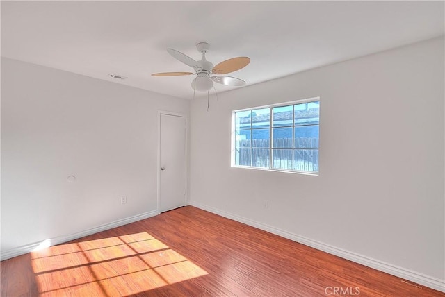 spare room with hardwood / wood-style flooring and ceiling fan