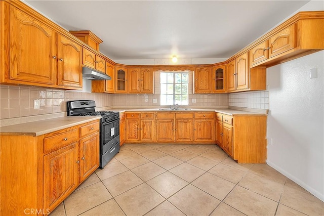 kitchen featuring range with gas stovetop, sink, decorative backsplash, and light tile patterned floors