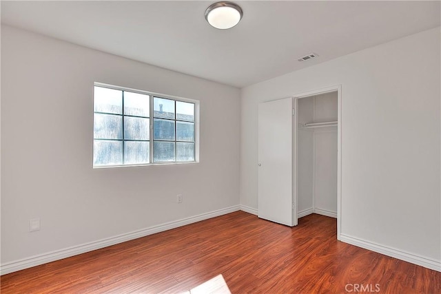 unfurnished bedroom with wood-type flooring and a closet