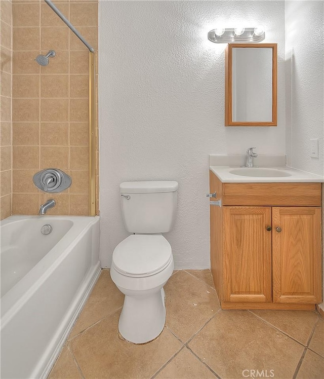 full bathroom featuring vanity, tiled shower / bath, tile patterned floors, and toilet