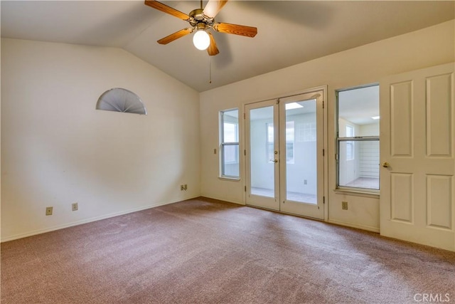 empty room with french doors, ceiling fan, carpet floors, and vaulted ceiling