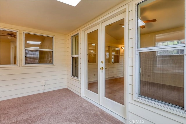 unfurnished sunroom featuring ceiling fan