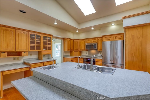 kitchen featuring a kitchen island with sink, sink, and appliances with stainless steel finishes