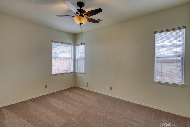 spare room featuring ceiling fan, light colored carpet, and plenty of natural light