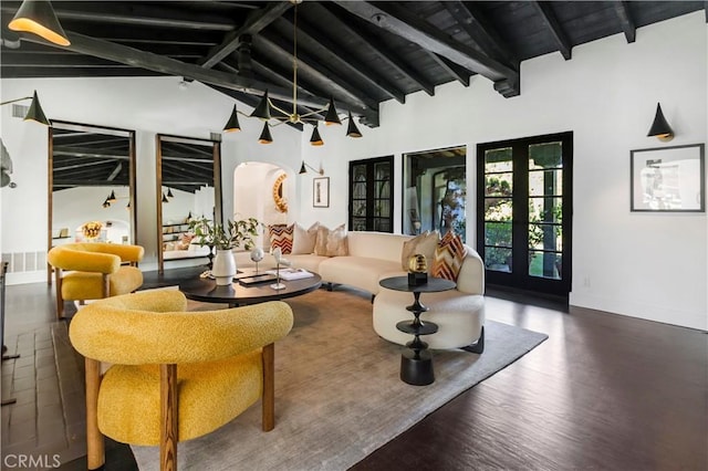 living area featuring visible vents, lofted ceiling with beams, wood finished floors, arched walkways, and baseboards