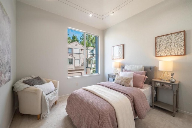 carpeted bedroom featuring track lighting