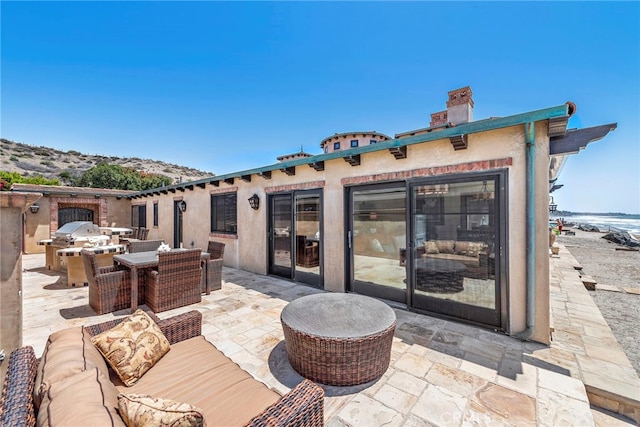 view of patio featuring a water view, area for grilling, and an outdoor hangout area