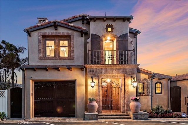 mediterranean / spanish home featuring a garage and a balcony