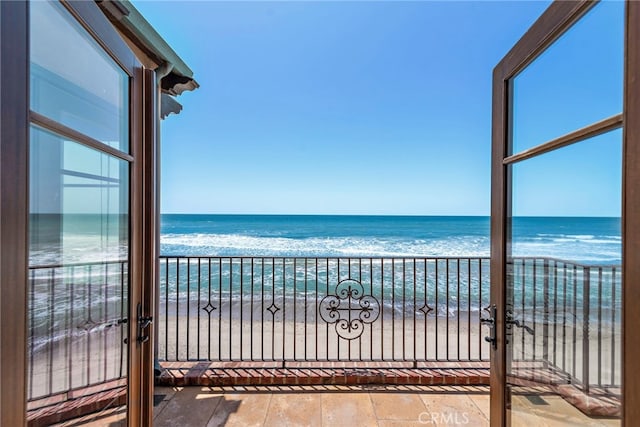 balcony featuring a water view and a view of the beach