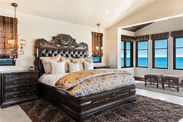 bedroom featuring a water view, vaulted ceiling, and light tile patterned floors