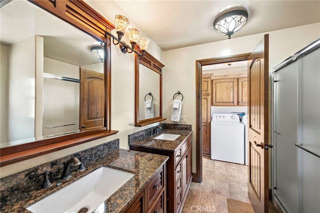 bathroom with vanity, washer / dryer, and walk in shower