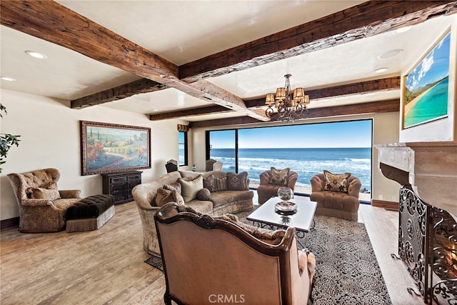 living room featuring a water view, beam ceiling, an inviting chandelier, and light hardwood / wood-style flooring