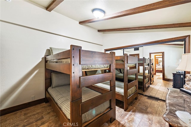 bedroom featuring hardwood / wood-style floors and lofted ceiling with beams