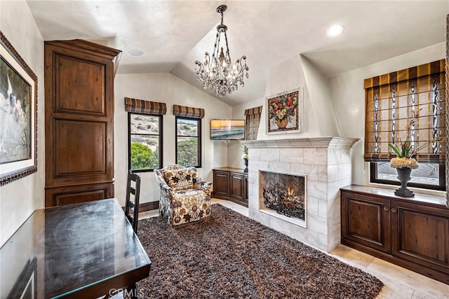 living area with an inviting chandelier, a tiled fireplace, and vaulted ceiling