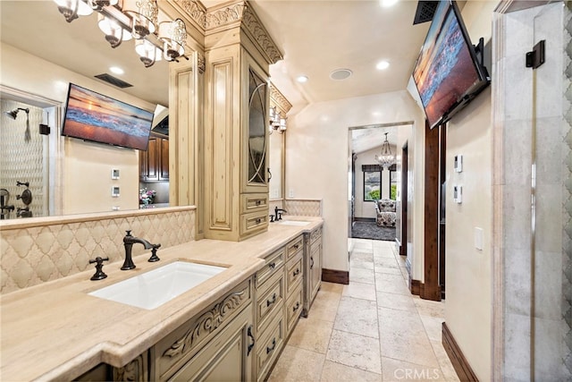 bathroom featuring tasteful backsplash, vanity, and an inviting chandelier