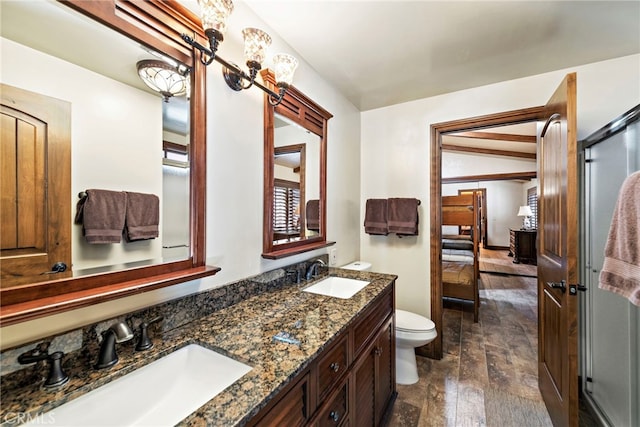 bathroom with hardwood / wood-style flooring, vanity, lofted ceiling, and toilet