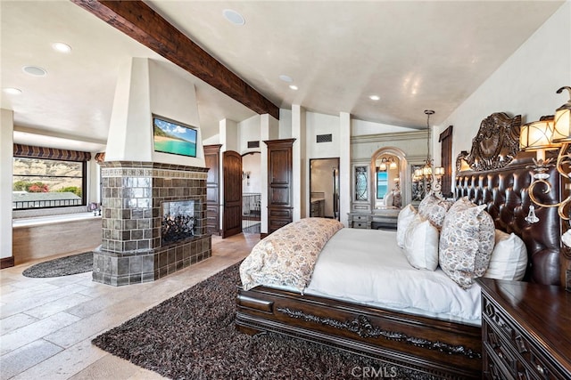 bedroom with lofted ceiling with beams and a tile fireplace