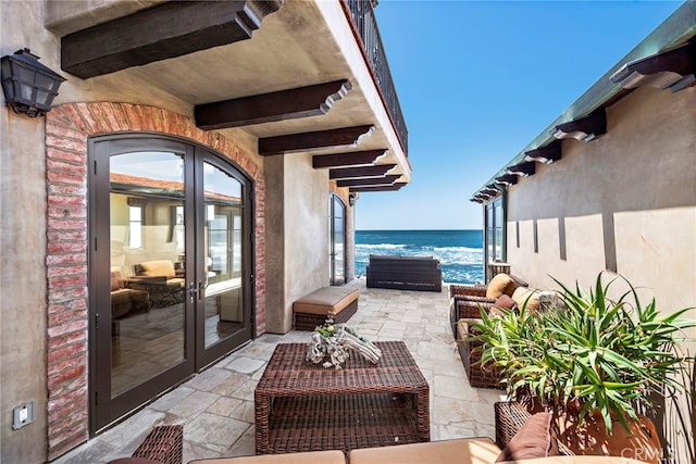 view of patio / terrace featuring an outdoor hangout area, french doors, and a water view