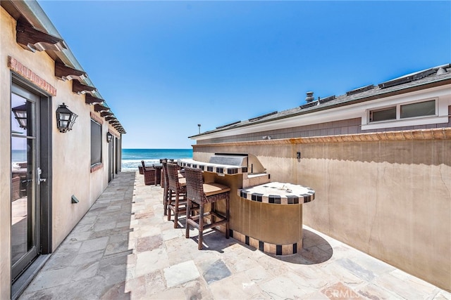 view of patio / terrace featuring a bar and a water view