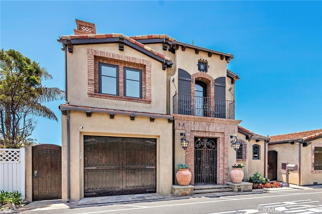 mediterranean / spanish home featuring a garage and a balcony