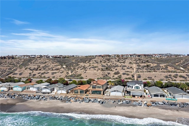 drone / aerial view with a water view and a beach view