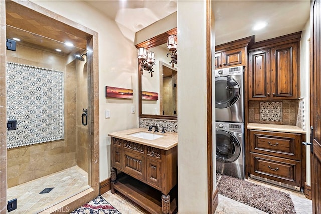 bathroom featuring walk in shower, stacked washer and dryer, vanity, and tasteful backsplash