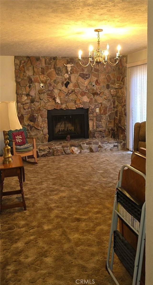 living room with a notable chandelier, carpet, a fireplace, and a textured ceiling