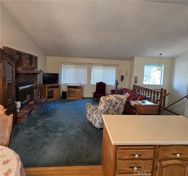 living room featuring vaulted ceiling, dark carpet, and a fireplace