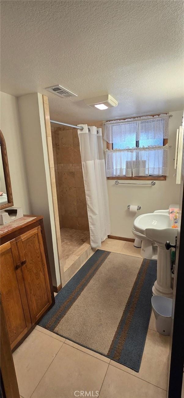 bathroom featuring a stall shower, tile patterned floors, visible vents, and toilet